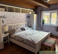 A bedroom with a wall featuring a tree design and a wooden-patterned floor in a family house.