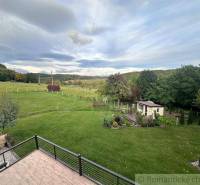 View from a family house in Lukovištia to a garden with a gazebo, lawn, and trees.