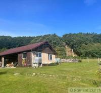 A family house in Lukovištia with a grassy plot and a forest environment in the background.