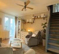 Living room in a two-room apartment with stairs and a wooden decor floor.