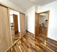 Interior of a 3-room apartment with a wooden decor floor and a built-in wardrobe.