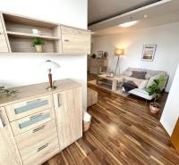 Interior of a 3-room apartment with a wooden decor floor and light furniture.