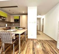 A kitchen in a 3-room apartment with a dining table and a wooden decor floor.