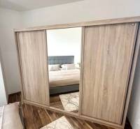 Mirrored wardrobe in the bedroom, 3-room apartment, floor with wood decor.