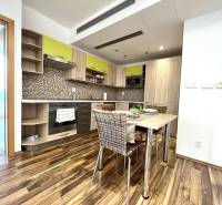 A kitchen in a 3-room apartment with mosaic tiles and a wooden decor floor.