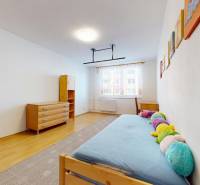 A simple room with a bed, furniture, and a floor with a wooden decor in a 3-room apartment.