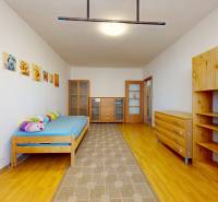 Children's room with wall decorations, wooden furniture, and a floor with a wooden design.