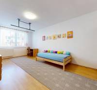 Children's room in a 3-room apartment with wooden decor, bed, and cabinets.