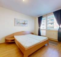 Bedroom in a 3-room apartment with a double bed and a floor with a wooden decor.