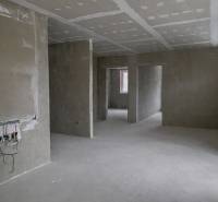 Unfurnished interior in a 3-room apartment with raw walls and preparations for electrical installations.