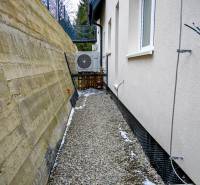 A narrow passage between a building and a retaining wall with air conditioning in Stará Ľubovňa.