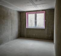 Unfinished room with a window and concrete floor in a 3-room apartment.
