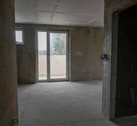 Unfinished interior of a 3-room apartment with large windows and concrete floor.