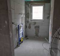 Bathroom construction in a 3-room apartment with toilet installation and a window.