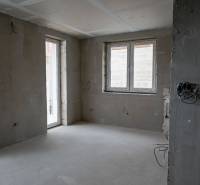 Unfinished interior of a 3-room apartment with raw walls and prepared electrical installation.