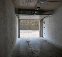 A spacious garage with open doors leading to the exterior in Stará Ľubovňa.