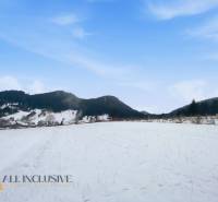 Snow-covered lands in Komjatná with a view of the surrounding mountains and blue sky.