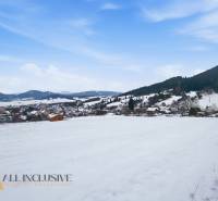 Snow-covered residential plots in Komjatná with views of the mountains and the village.