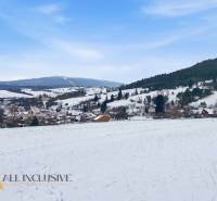 Snowy landscape of Komjatná with a view of dwellings and hills, suitable for plots - housing.
