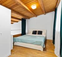 Bedroom with a double bed, storage wardrobe, and wooden decor flooring in a family house.