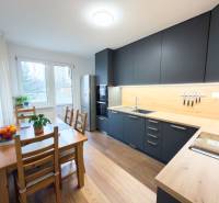 A kitchen in a 4-room apartment with a wooden decor floor and a dining table.