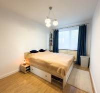 Bedroom in a 4-room apartment with a bed, wood-patterned flooring, and curtains.
