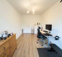 A study in a 4-room apartment with a wood-patterned floor and a computer desk.