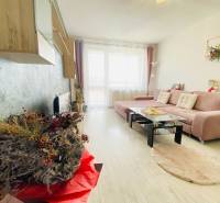 Living room in a three-room apartment with a wooden decor floor and a comfortable corner sofa.