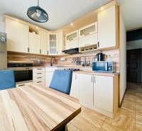A kitchen in a 3-room apartment with wooden decor, a table, and modern appliances.