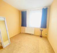 A room in a 3-room apartment with a mirror, curtains, and a radiator.