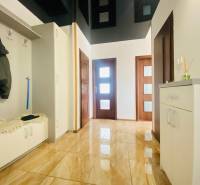 A hallway with a shiny floor and a coat rack in a 3-room apartment.