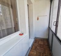 Glazed balcony in a 2-room apartment with a wooden decor floor.