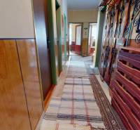 A hallway with wooden decor and carpet in a family house, decorative metal elements.