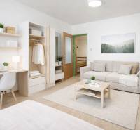 Living room in a family house with a sofa, table, built-in wardrobe, and floor with a wooden decor.
