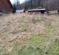 A plot for residential use in Oščadnica surrounded by wooden structures and forest.