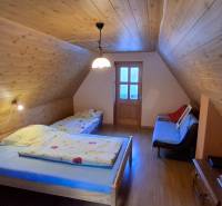 Wooden interior of a cabin with a bed and a floor with a wooden design.