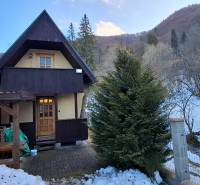 A wooden cabin in the snowy area of Poviny with a shelter and a winter atmosphere.