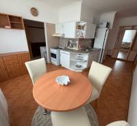 Kitchen corner with seating in a 3-room apartment, with a wooden decor floor.