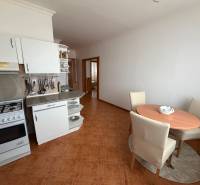 A kitchen in a 3-room apartment with a dining nook and a wooden decor floor.
