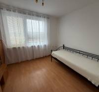 A room with a wooden floor decor and a bed in a 3-room apartment.