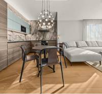 Kitchen and living room in a 2-room apartment with a wooden decor floor and a comfortable sofa.