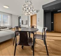 Interior of a 2-room apartment with a wooden decor floor, a round table, and lighting.