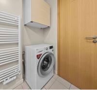 Bathroom with a washing machine and a radiator in a 2-room apartment.