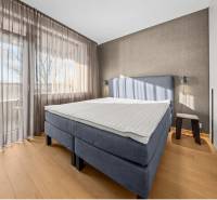 Bedroom in a 2-room apartment with a bed, wardrobes, and a floor with a wooden decor.