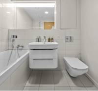 Bathroom in a 2-room apartment with a bathtub, sink, and wall-hung toilet.