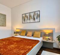 Bedroom in a 2-room apartment with a bed, decoration, and floor with wood decor.