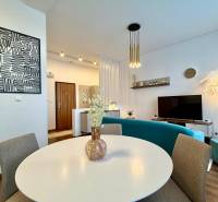 Interior of a 2-room apartment with a wooden decor floor, modern seating, and a table.