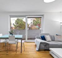 Living room with wood-patterned flooring, a sofa, and an elegant table in a two-room apartment.