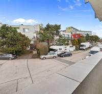 View from the balcony on Ďumbierska Street, Bratislava - Vinohrady, with cars and greenery.