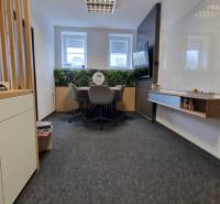 Offices with a conference table, comfortable chairs, and a green wall.